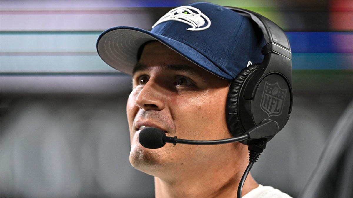 Seattle Seahawks head coach Mike Macdonald wearing a value cap and headset.