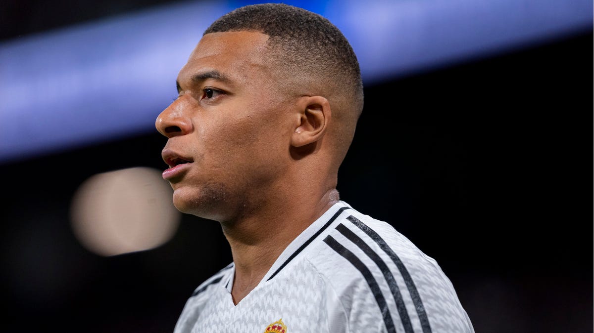 Side-on image of Real Madrid star Kylian Mbappe looking onwards.  