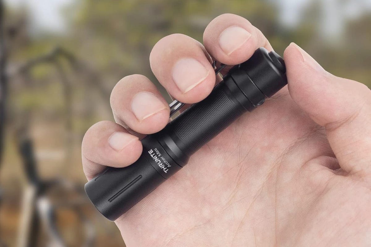 A Thrunight flashlight held in a hand