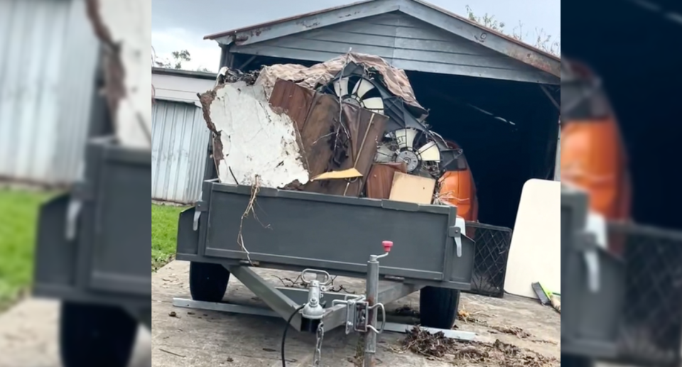 The stolen trailer in Laverton can be seen parked on a driveway full of broken furniture, wood and garden waste. 