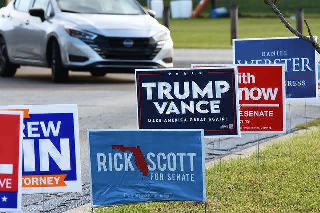 <p>Paul Hennessy/Anadolu/Getty</p> Campaign signs outsides of an early voting center in Orlando, Florida on Oct. 21.