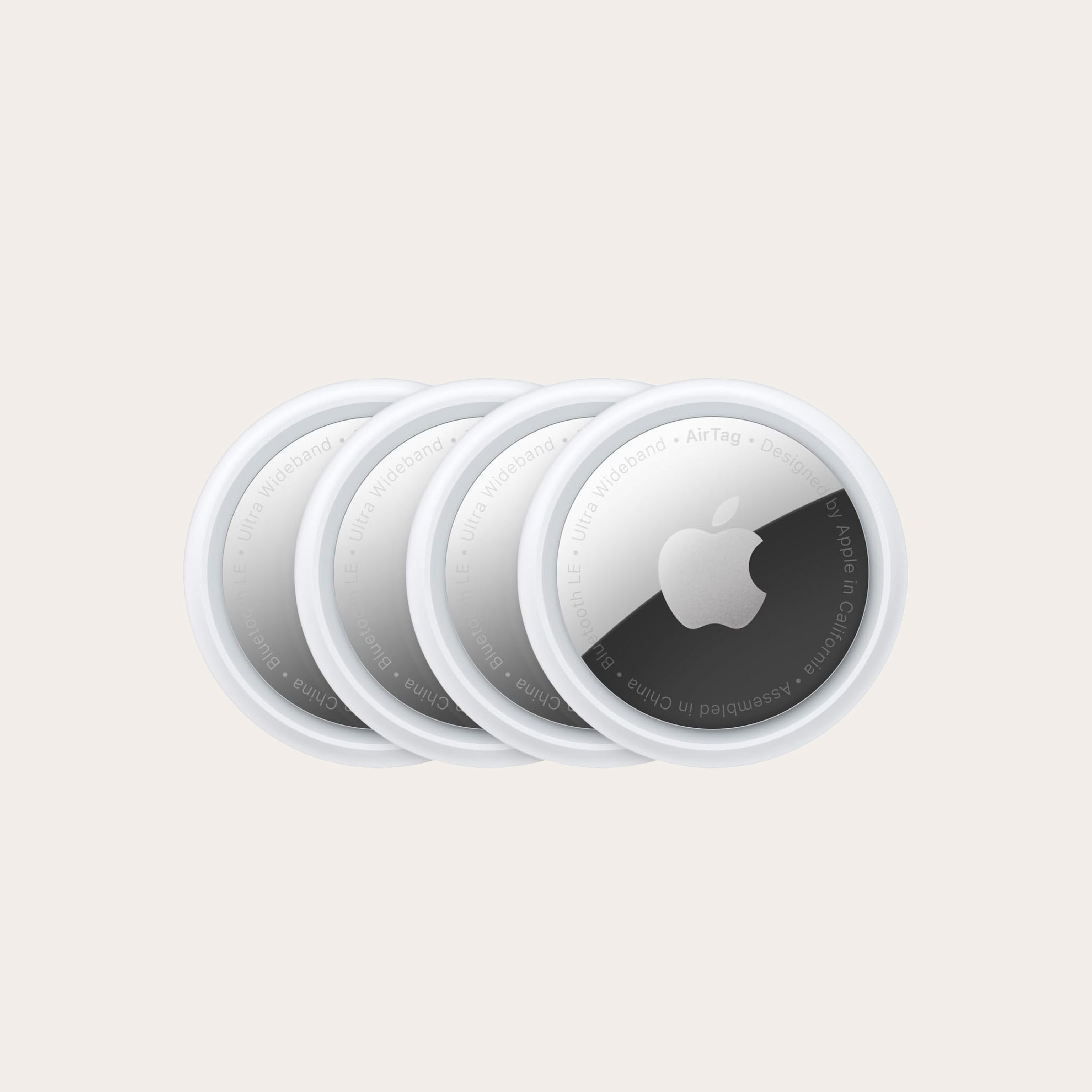 Four round silver devices with apple logo placed on a tan background.