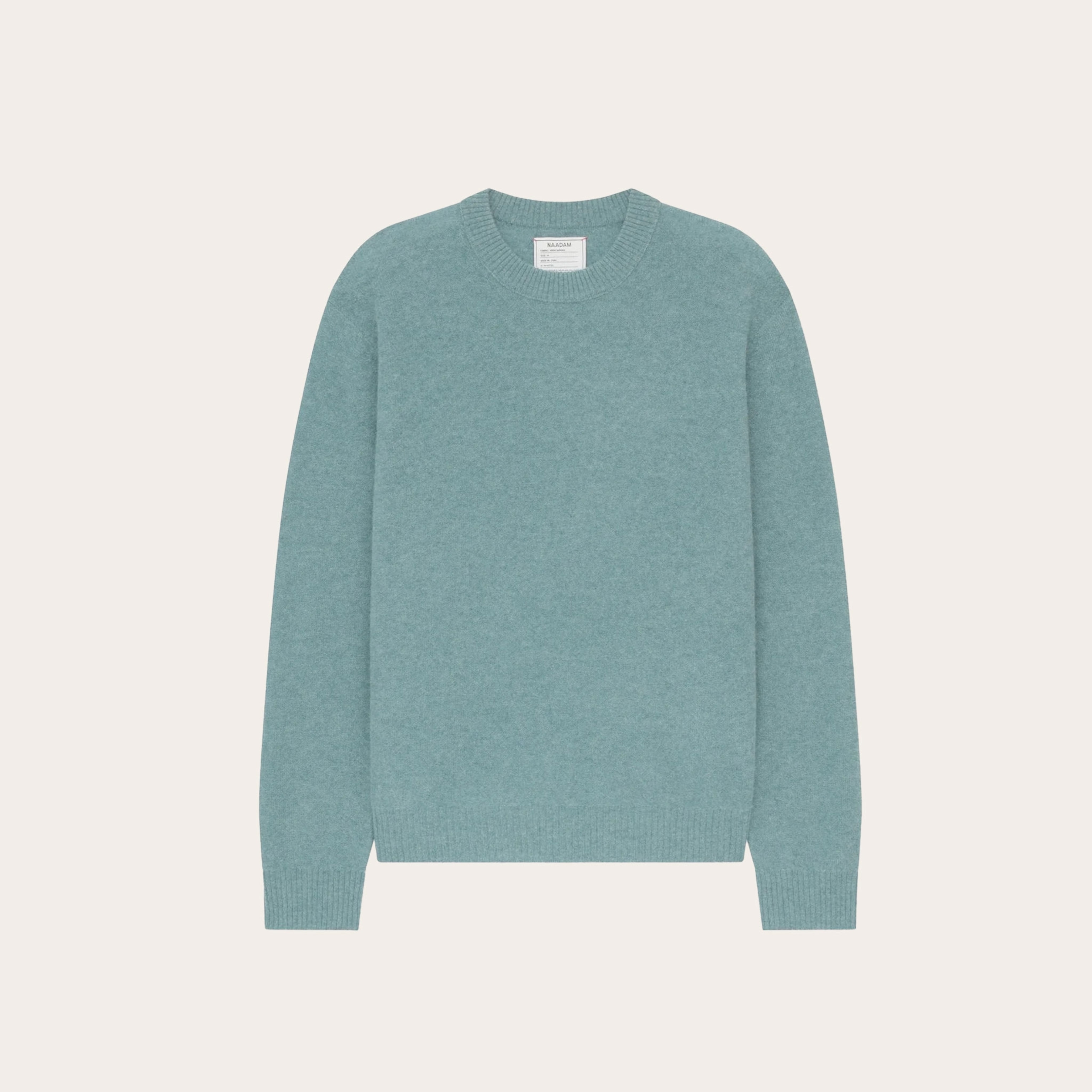 Light blue sweater placed on tan background