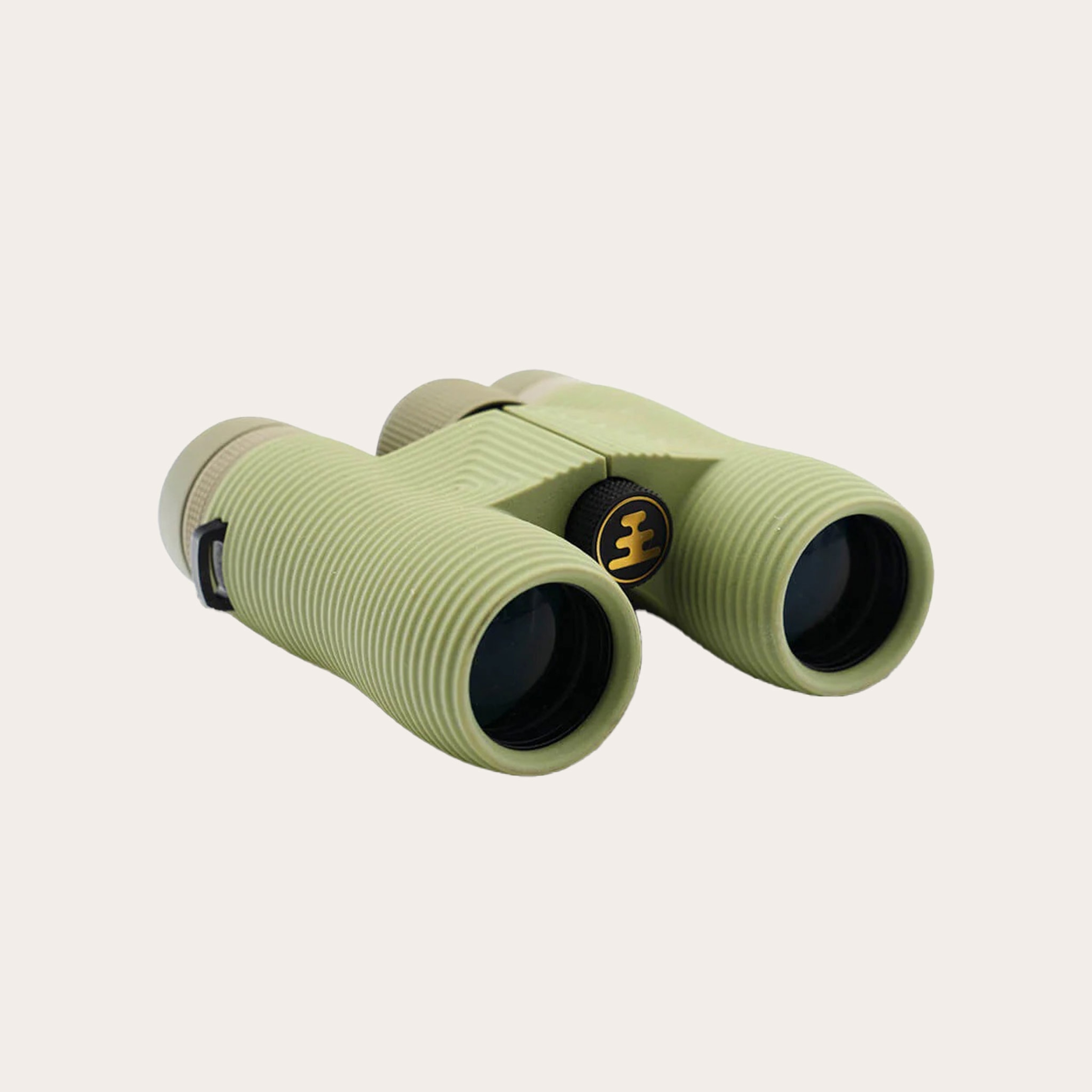 Green binoculars placed on tan background.