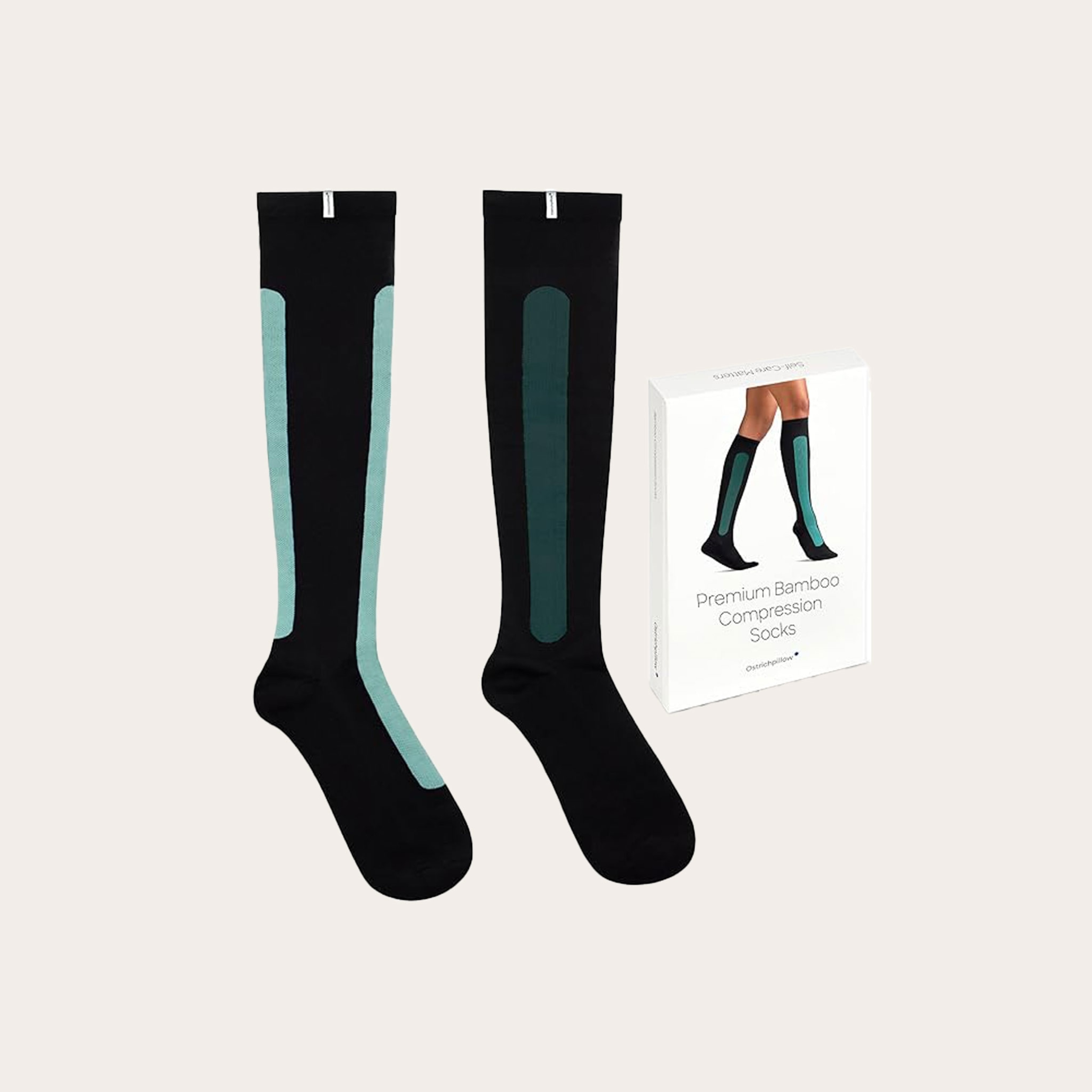 Black and teal compression socks and packaging placed on a tan background.