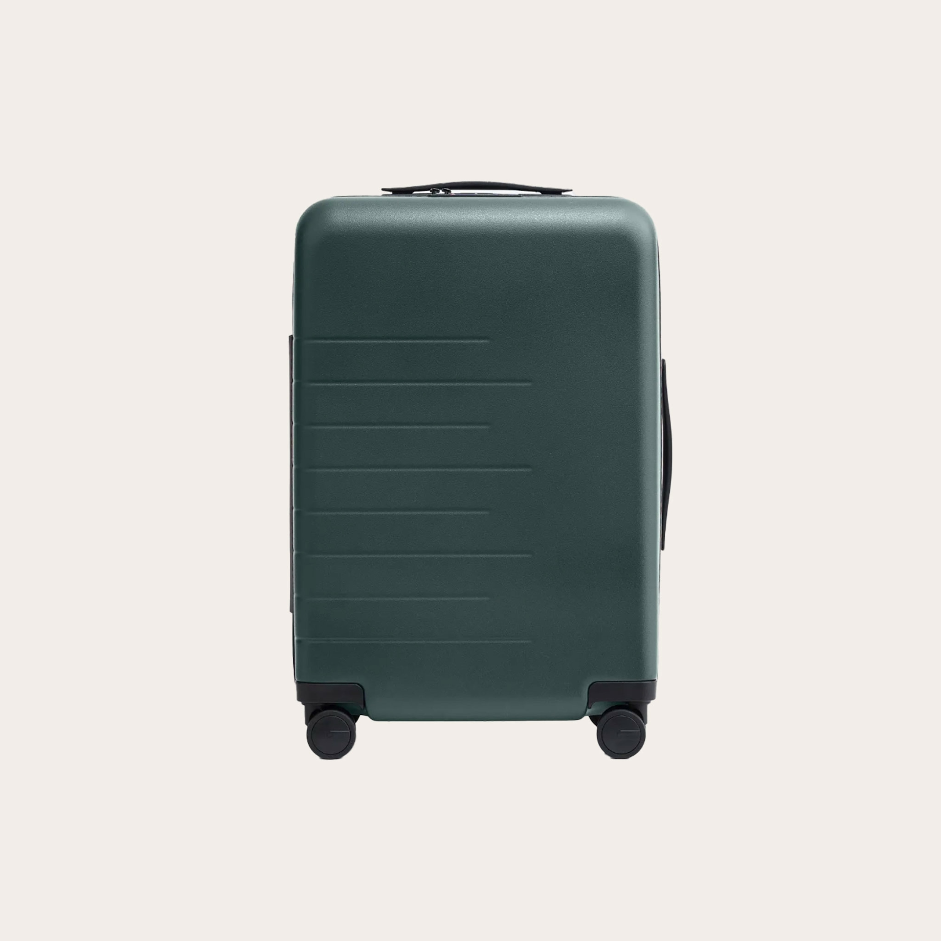 Dark green suitcase placed on tan background.