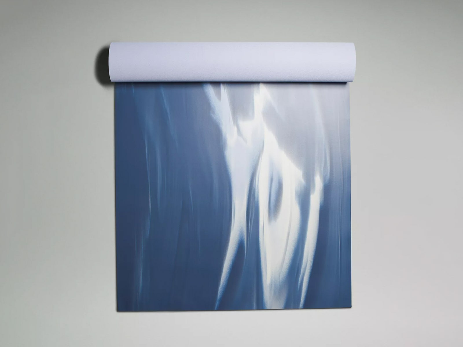 Blue and white yoga mat partially rolled up