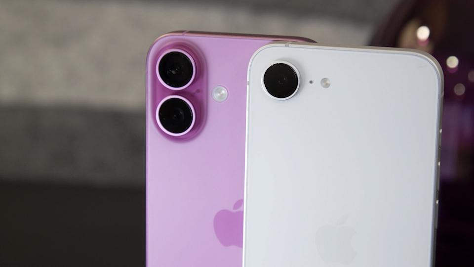 A pink iPhone 16 standing slightly behind the 16e, with just the top halves of the handsets visible in the scene.
